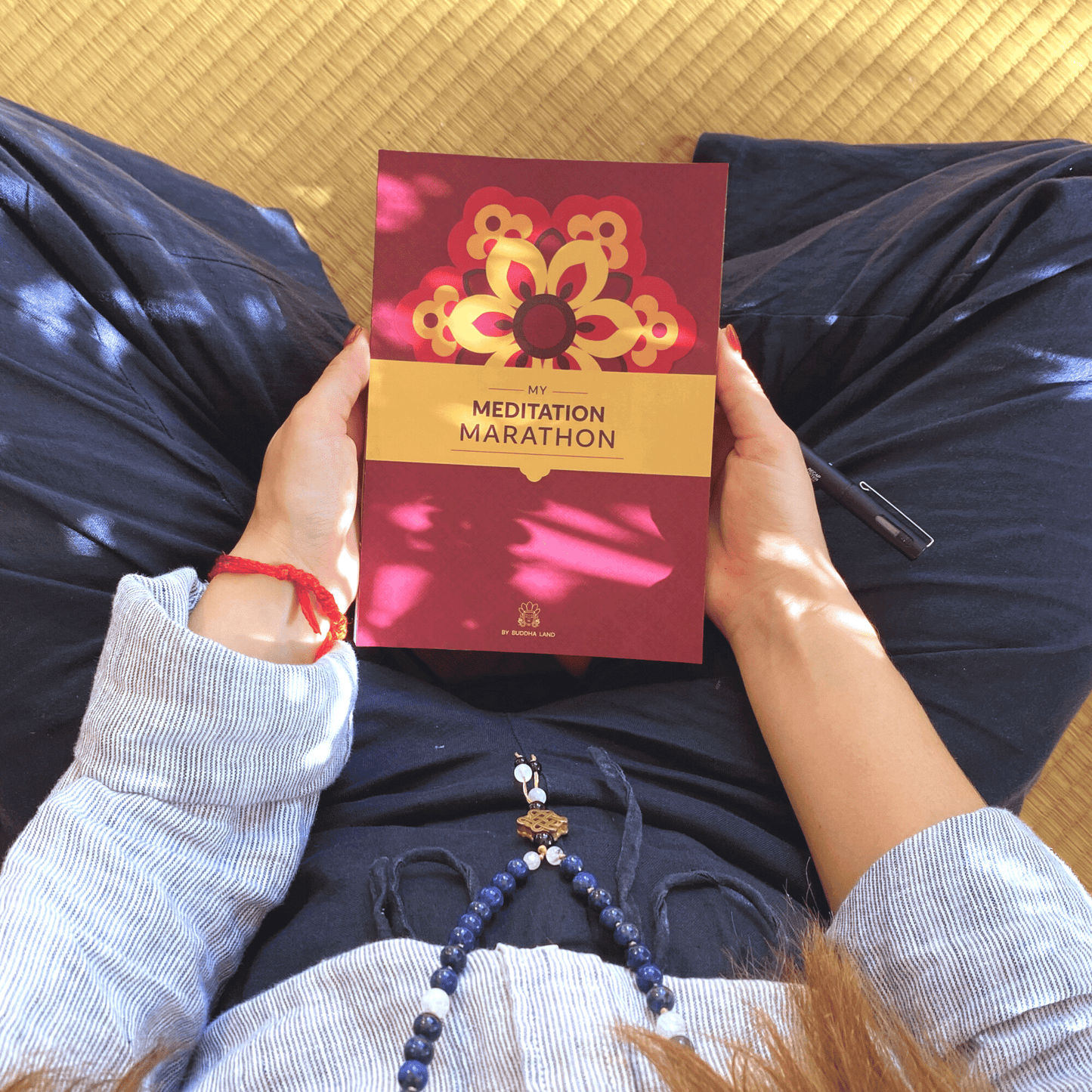 Woman holding My Meditation Marathon mindfulness journal in her lap.