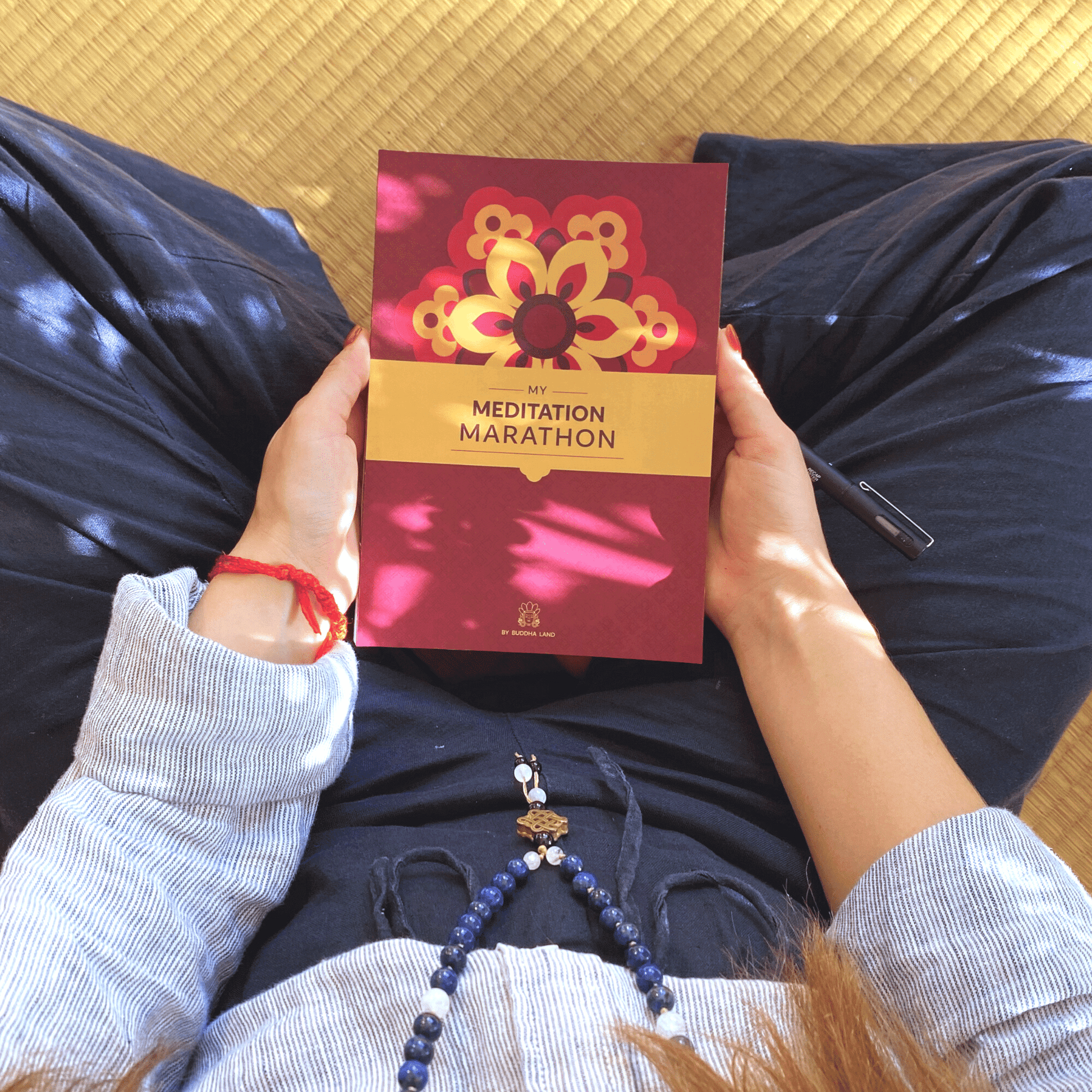 Woman holding My Meditation Marathon mindfulness journal in her lap.
