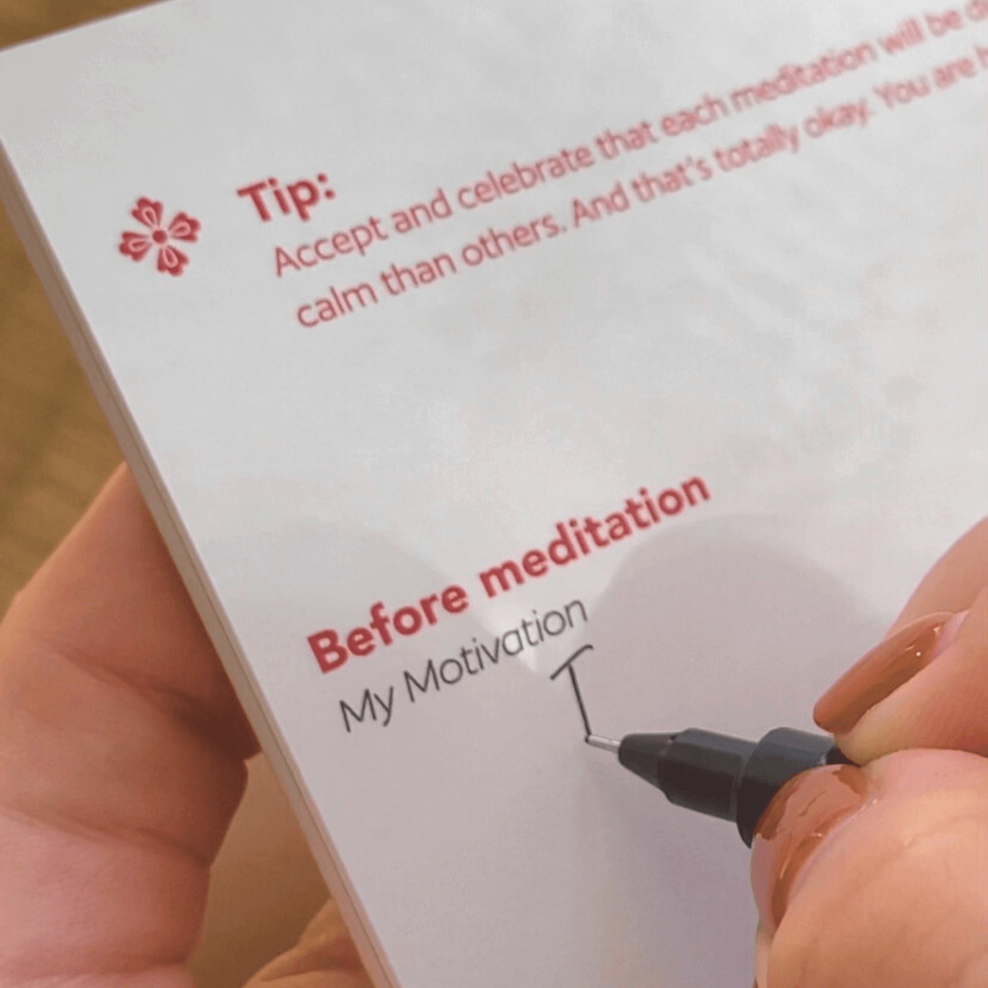Close up of someone writing in a meditation and mindfulness journal.